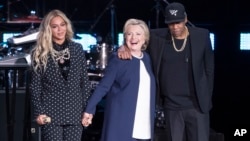 Jay Z, right, and Beyonce, left, stand with Democratic presidential candidate Hillary Clinton during a campaign rally in Cleveland, Nov. 4, 2016. 