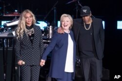 FILE: Jay-Z, right, and Beyonce, left, stand with Democratic presidential candidate Hillary Clinton during a campaign rally in Cleveland, Nov. 4, 2016.