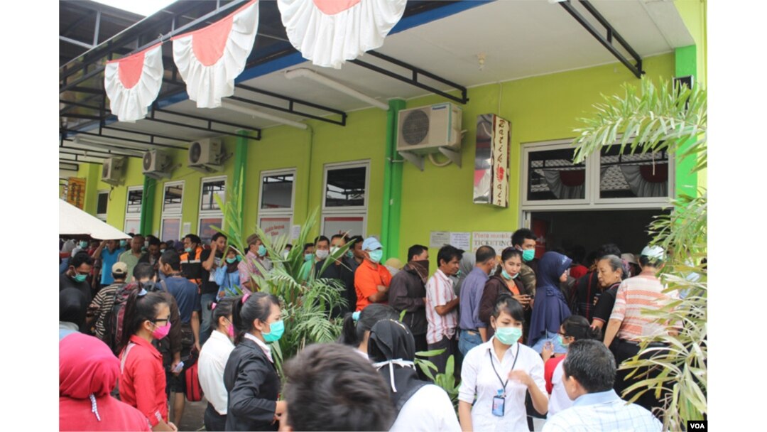 Para penumpang antri untuk mengembalikan atau menunda tiket perjalanan dengan pesawat di Bandara Adisucipto, Yogyakarta, Sabtu, 15 Februari 2014 (VOA/Munarsih)
