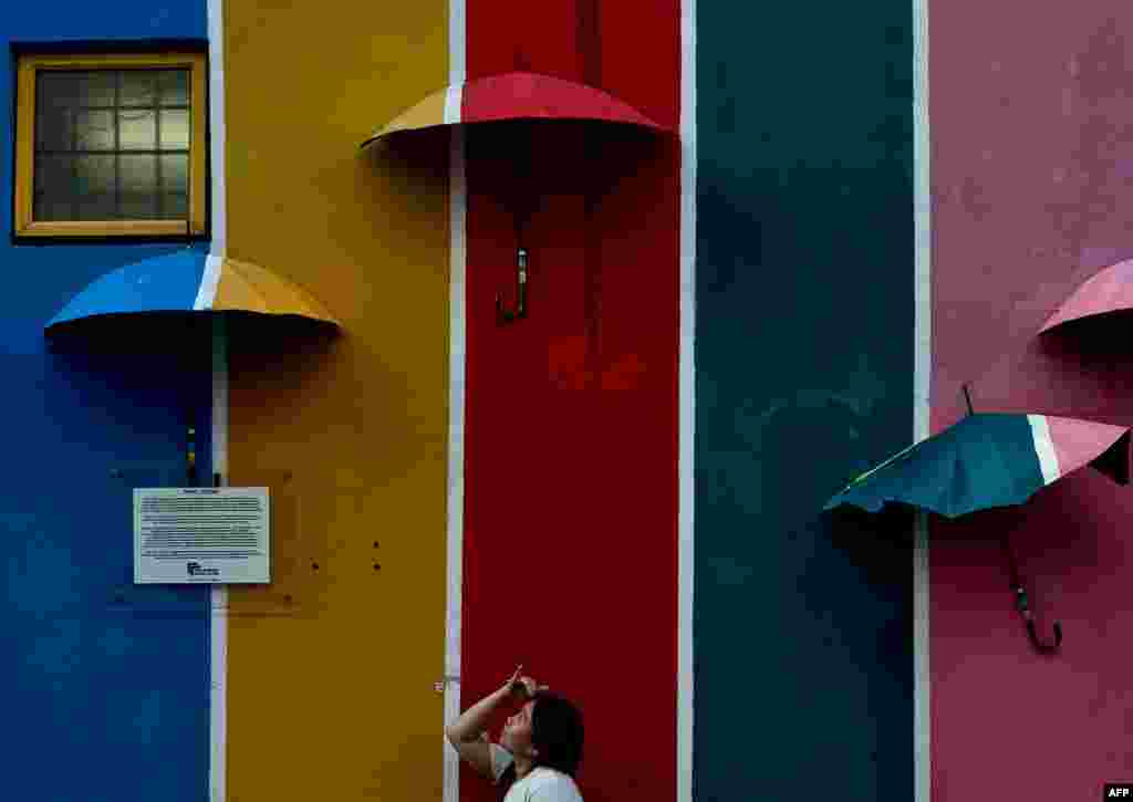 A Malaysian girl is seen in front of a mural at an alley in Shah Alam.