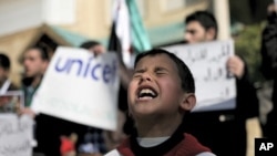 A Syrian boy chants slogans during a rally demanding UNICEF to protect Syrian children in front of the UNICEF Compound in Amman, Jordan, February 20, 2012.