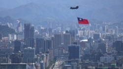 一架懸掛台灣旗幟的支奴干直升機在台北市上空飛行。（2021年10月7日）