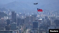 一架悬挂台湾旗帜的支奴干直升机在台北市上空飞行（2021年10月7日）
