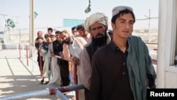 پاکستان اور افغانستان کے درمیان واقع ایک سرحدی گزر گاہ پر شہری افغانستان میں داخلے کی اجازت ملنے کا انتظار کر رہے ہیں۔ (فائل فوٹو)