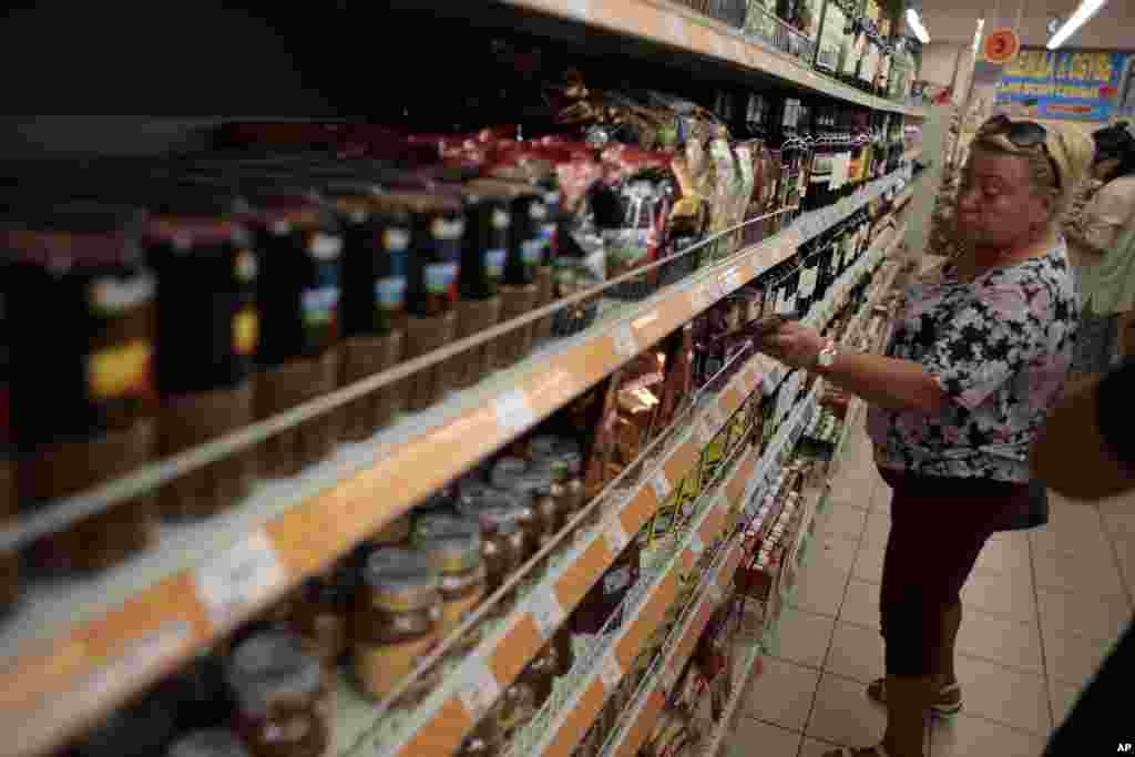 Seorang perempuan membeli permen dari bagian makanan impor di sebuah toserba di tengah kota Moskow, 7 Agustus 2014.