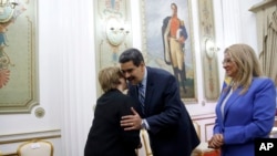 Komisaris HAM PBB, Michelle Bachelet, kiri disambut Presiden Venezuela, Nicolas Maduro, sementara, ibu negara Cilia Flores mendampingi di Istana Presiden Miraflores di Caracas, Venezuela, Jumat, 21 Juni 2019 (foto: AP Photo/Ariana Cubillos)