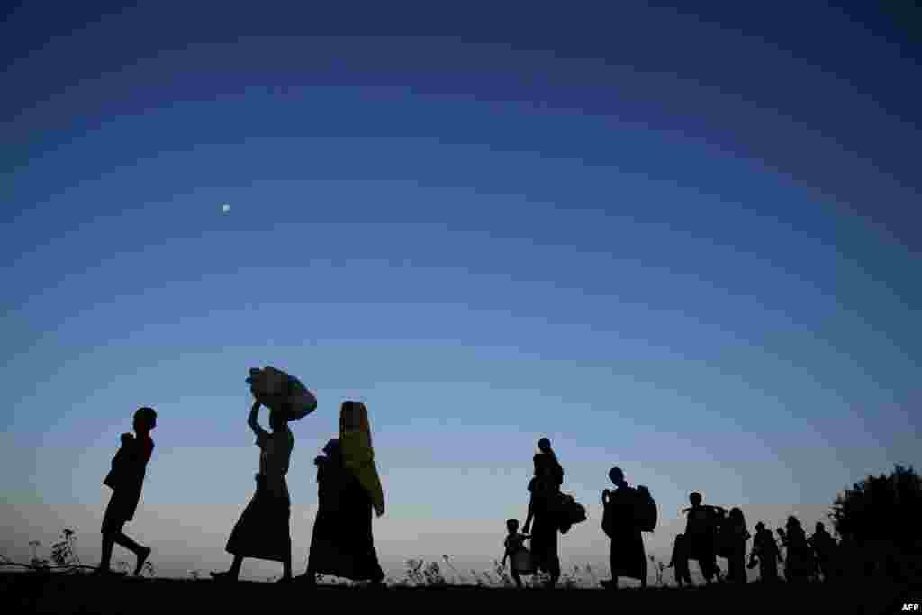 Rohingya Muslim refugees who were entered Bangladesh by boat, walk towards refugee camps after landing in the Bangladeshi district of Teknaf.