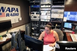A woman works at the WAPA 680 radio station, in San Juan, Puerto Rico, Sept. 27, 2017.