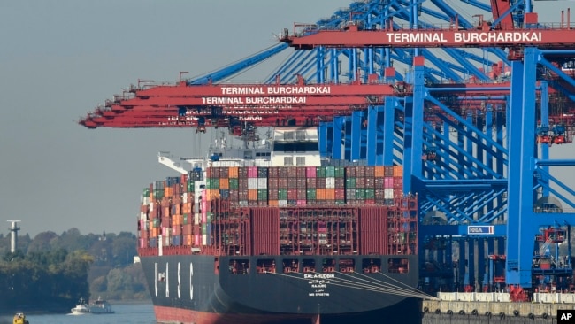 资料照片：正在德国汉堡港口卸货的集装箱货轮（2018年10月15日）