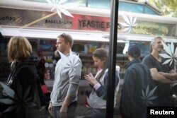 FILE - Customers queue for recreational marijuana outside the MedMen store in West Hollywood, California, Jan. 2, 2018.