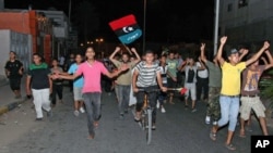 People in Tajura, a suburb of Tripoli, celebrating in the early morning on August 22, 2011 after Libyan rebels surged into Tripoli in a final drive to oust leader Gadhafi