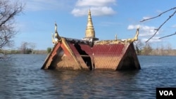 A curving roof of a small wooden pagoda juts above the water line in Srekor village of Stung Treng province, which has been affected flooding caused by Lower Sesan 2 Dam, Nov 28, 2018. (Sun Narin/VOA Khmer)