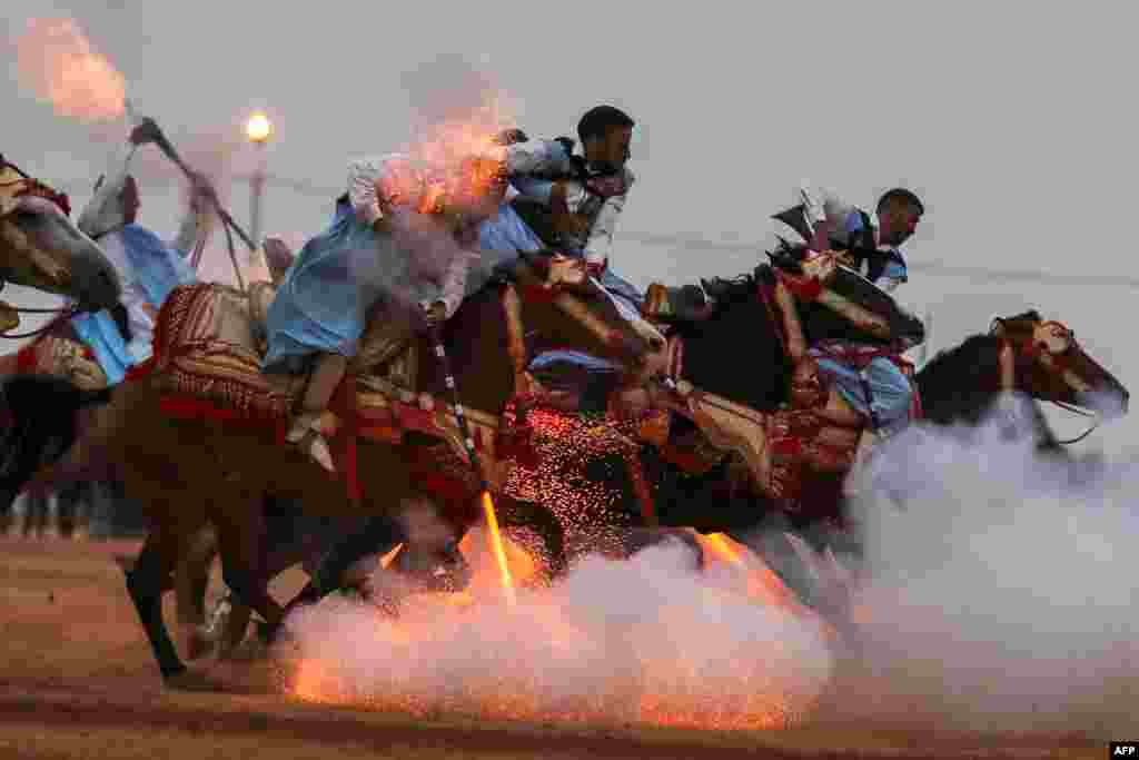 Horsemen ride during the 14th Tan-Tan Moussem Berber festival in the western Moroccan desert town of Tan-Tan, Morocco.