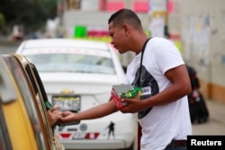 A Venezuelan migrant sells candy at a street in Tumbes, Peru, Aug. 25, 2018.