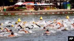 Swimmers compete in a race organized by the Paris Swim association, in the La Villette basin, Paris, Sept. 3, 2017.