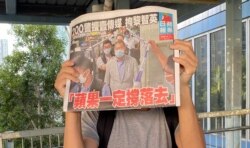 市民在天水围西铁站外领取8月11日的免费苹果日报，高举头版以示支持。 (美国之音汤惠芸)