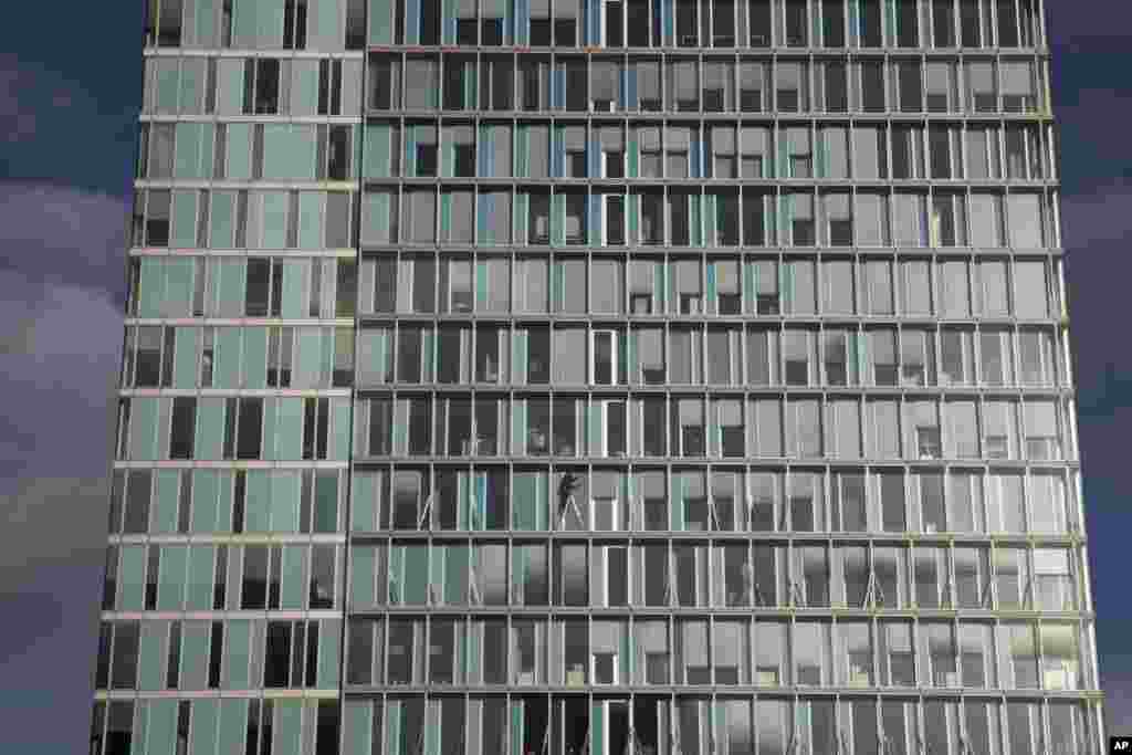 A window cleaner uses a step ladder at Amsterdam&#39;s Zuidas business district, Netherlands.