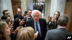 FILE - Sen. Bernie Sanders, I-Vt., center, speaks to reporters on Capitol Hill in Washington.