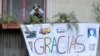 Un niño saluda desde un balcón en Barcelona, España, detrás de un cartel de apoyo a los trabajadores de la salud que luchan contra el coronavirus, el 11 de abril de 2020.
