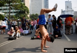 Seorang pria melakukan "handstand" di jalan utama pada "car free day" hari Minggu saat ribuan orang keluar untuk berolahraga di Jakarta (ilustrasi).