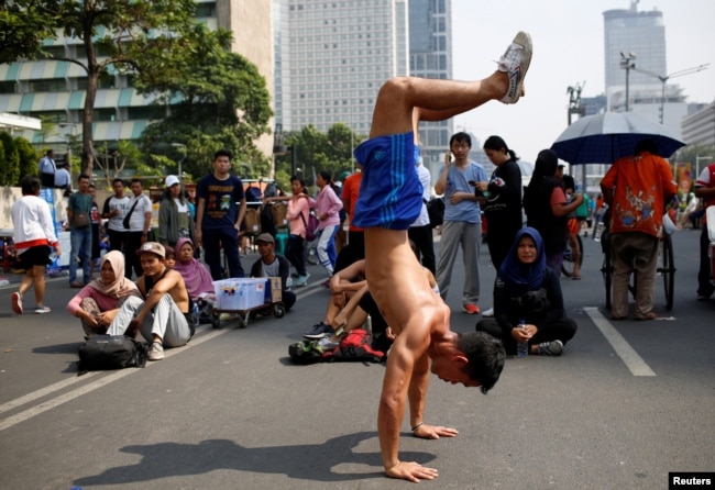 Seorang pria melakukan "handstand" di jalan utama pada "car free day" hari Minggu saat ribuan orang keluar untuk berolahraga di Jakarta (ilustrasi).