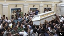 Egyptian Christians carry the coffin of one of the victims of Saturday night's clashes with Muslims in the streets of western Cairo, during a funeral ceremony at Giza church, Sunday, May 8, 2011
