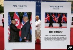 Photos of the summit between U.S. President Donald Trump and North Korean leader Kim Jong Un are displayed during a photo exhibition to wish for peace on the Korean Peninsula in Seoul, South Korea, Wednesday, Sept. 19, 2018.