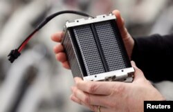 An employee holds an hydrogen fuel battery of an Alpha bike, first industrialized bicycle to use a hydrogen fuel cell at the Pragma Industries factory in Biarritz, France, Jan. 15, 2018.