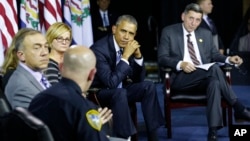 FILE - President Barack Obama and others listen to Charleston Police Chief Brent Webster, foreground, during an event at Charleston, W.Va., where Obama hosted a community discussion on prescription drug and heroin abuse, Oct. 21, 2015.