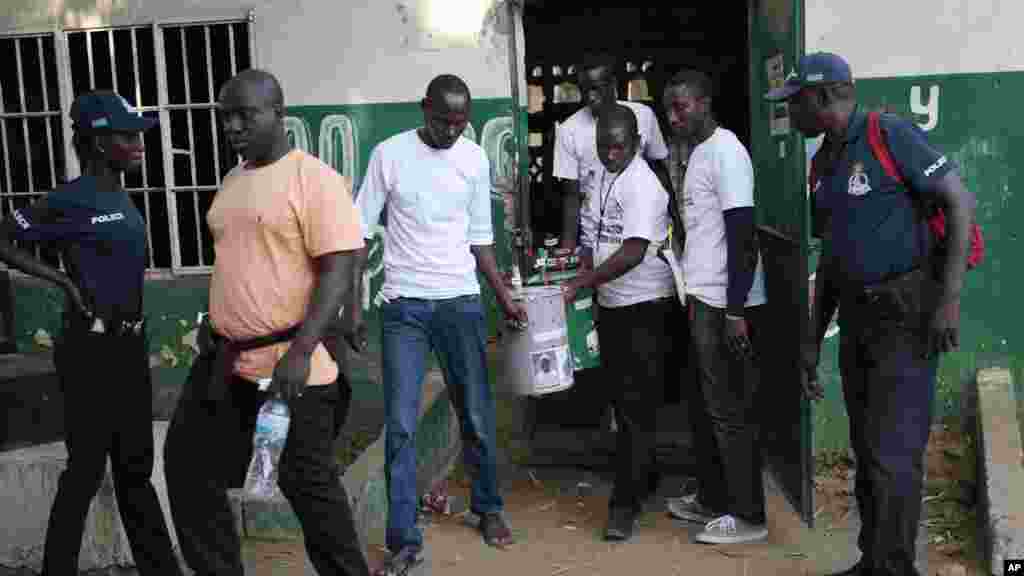 Des volontaires électoraux portent trois tonneaux servant d&rsquo;urnes avant la séance de comptage des voix lors de l&rsquo;élection présidentielle, à Serrekunda, Gambie, 1er décembre 2016.