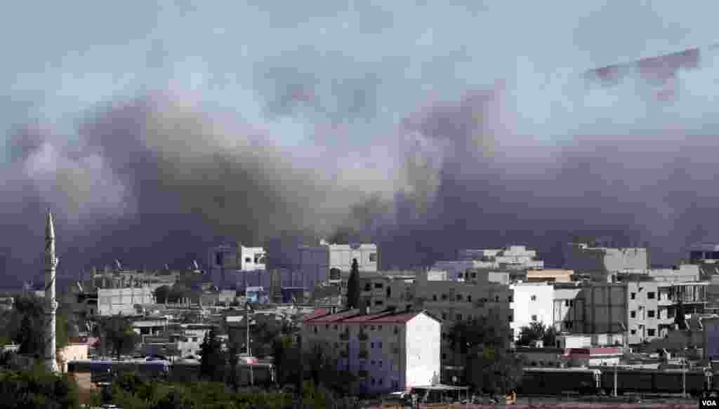 Smoke from a strike rises as seen from a hilltop on the outskirts of Suruc, at the Turkey-Syria border, Oct. 23, 2014. 