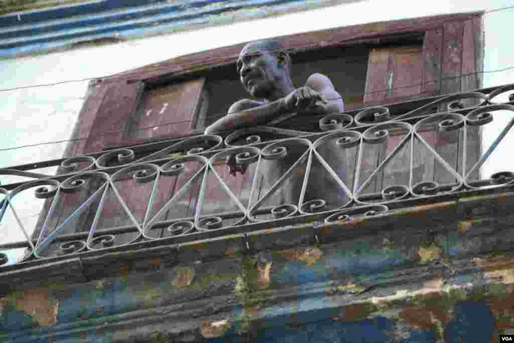 A Cuban man looks into the street from his balcony, in Havana, Aug. 13, 2015. (Celia Mendoza/VOA)
