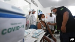 Seorang wanita dari kelompok Ticuna Indigenous, Brazil, mendapatkan suntikan vaksin Covid-19 yang diproduksi oleh China Sinovac Biotech Ltd. (Foto: AP)