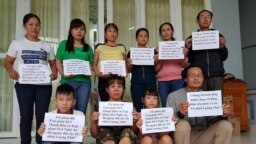 Những người vợ của tù nhân lương tâm cùng ôm bảng phản đối nhà cầm quyền ngược đãi tù nhân. (Facebook Tuyệt thực vì TNLT - Nguồn Ngọc Tuyên Đàm)