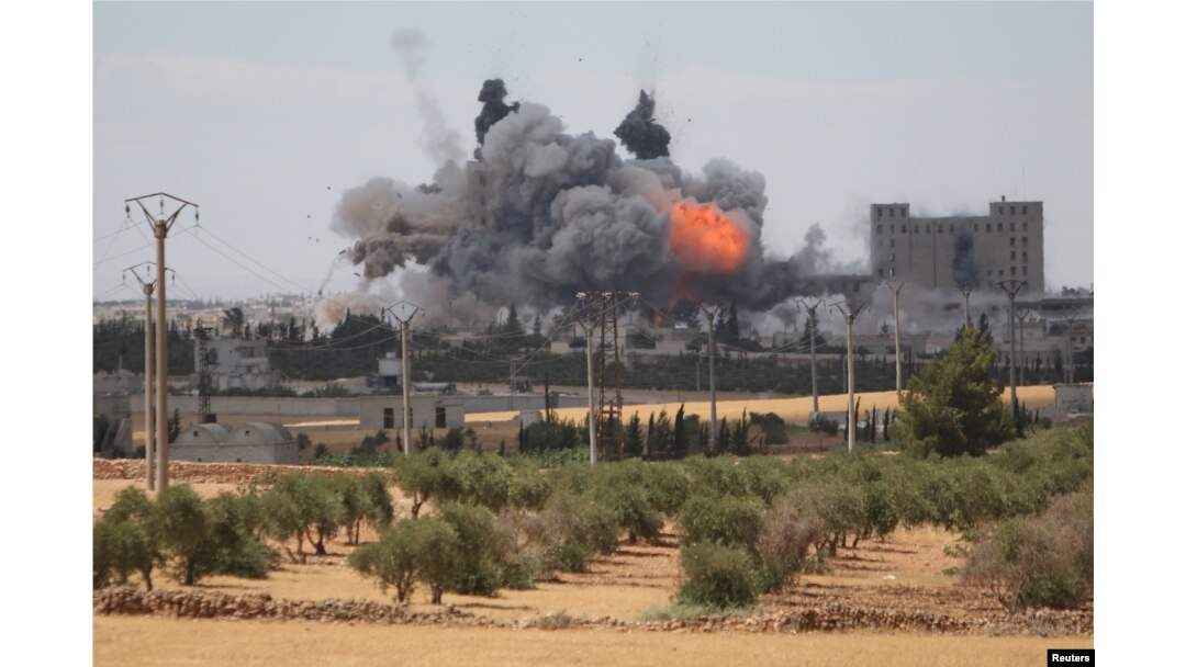FILE - Smoke and flame rise after what fighters of the Syria Democratic Forces (SDF) said were U.S.-led air strikes on the mills of Manbij where Islamic State militants are positioned, in Aleppo Governorate, Syria, June 16, 2016.