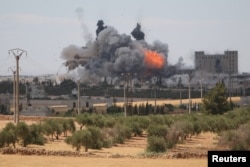 FILE - Smoke and flame rise after what fighters of the Syria Democratic Forces (SDF) said were U.S.-led air strikes on the mills of Manbij where Islamic State militants are positioned, in Aleppo Governorate, Syria, June 16, 2016.