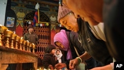 Tibetan Buddhist exiles offer prayers as they light butter lamps to show solidarity with Tibetans who have either set themselves on fire or were allegedly injured or killed in clashes with Chinese police, in New Delhi, India, February 9, 2012.