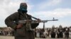  A member of the Taliban stands with others at the execution of three men in Ghazni Province, April 18, 2015. Residents of the area say Islamic State has threatened them to stop supporting the Taliban and support Islamic State instead.