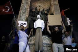 FILE - Supporters of Turkish President Tayyip Erdogan hold an effigy of U.S.-based cleric Fethullah Gulen hanged by a noose on the Republic Monument, during a pro-government demonstration on Taksim Square in Istanbul, Turkey, July 18, 2016.