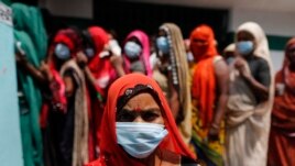 People wait to cast their votes during local panchayat elections on the outskirts of Prayagraj, in the northern Indian state of Uttar Pradesh, Thursday, April 15, 2021. India reported more than 200,000 new coronavirus cases Thursday.