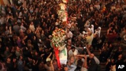 Mourners carry the coffins of slain Christians during their funeral in Baghdad, Iraq, Tuesday, Nov. 2, 2010. The victims were killed Sunday when gunmen stormed a church during mass and took the entire congregation hostage.