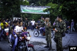 FILE - Moro Islamic Liberation Front (MILF) members secure Camp Darapanan on the southern island of Mindanao, July 29, 2018. Nearly 100,000 members of the Philippines' largest Muslim rebel group gathered to discuss a landmark law granting them autonomy.