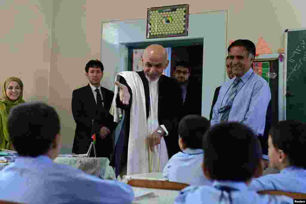 Afghan President Ashraf Ghani speaks with students during his visit to the Amani High School in Kabul, Sept. 30, 2014.