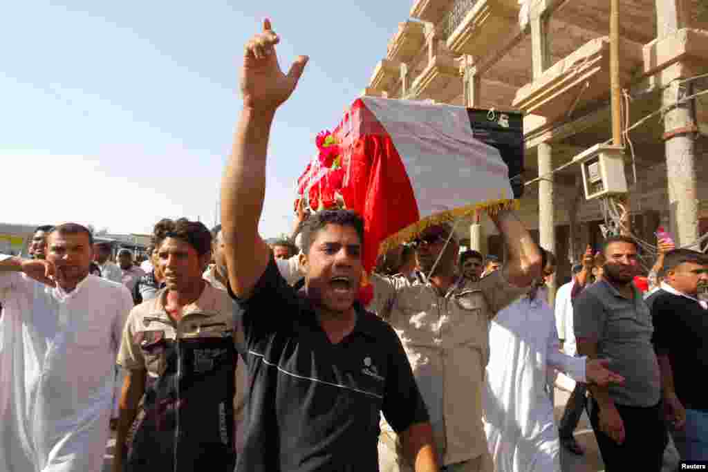 Mourners carry the coffin of a Shi'ite volunteer who joined the Iraqi army and was killed during clashes with the Islamic State of Iraq and the Levant, Najaf, Iraq, June 28, 2014. 