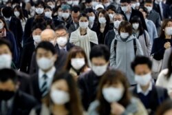 People wear face masks at Shinagawa station during the rush hour after the government expanded a state of emergency to include the entire country following the coronavirus disease (COVID-19) outbreak, in Tokyo, Japan, April 20, 2020.