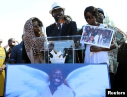 FILE - Apollo Olango, center, brother of Alfred Olango, speaks to a crowd of supporters as demonstrators hold a rally to protest the fatal police shooting of Ugandan immigrant Alfred Olango in El Cajon, California, Oct. 1, 2016.