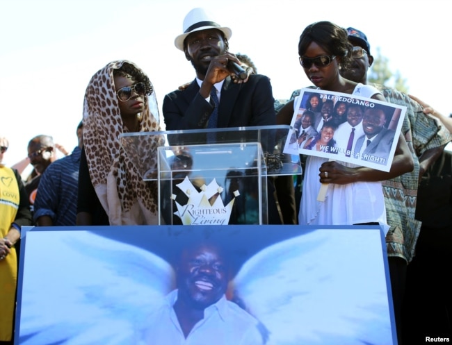 FILE - Apollo Olango, center, brother of Alfred Olango, speaks to a crowd of supporters as demonstrators hold a rally to protest the fatal police shooting of Ugandan immigrant Alfred Olango in El Cajon, California, Oct. 1, 2016.