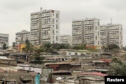 FILE - High-rise buildings are seen behind informal settlements in the capital of Luanda, Angola, Aug. 30, 2012.