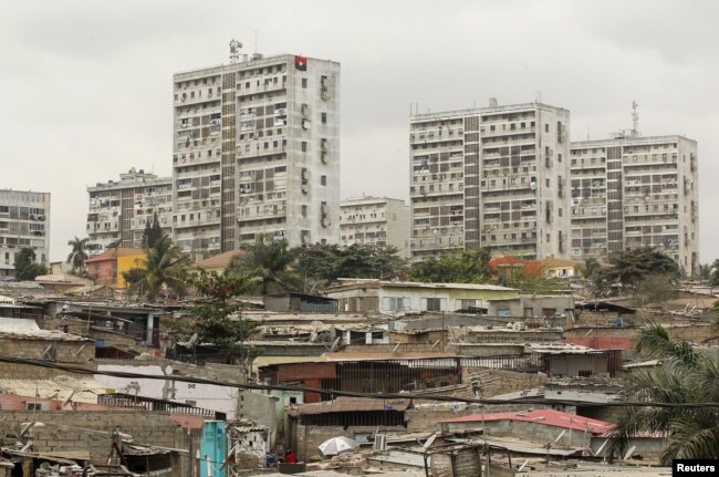 FILE - High-rise buildings are seen behind informal settlements in the capital of Luanda, Angola, Aug. 30, 2012.