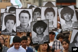 Demonstrators shouts slogans against pardon of former President Alberto Fujimori with photographs of people disappeared during his government, in Lima, Peru, Monday, Dec. 25, 2017.